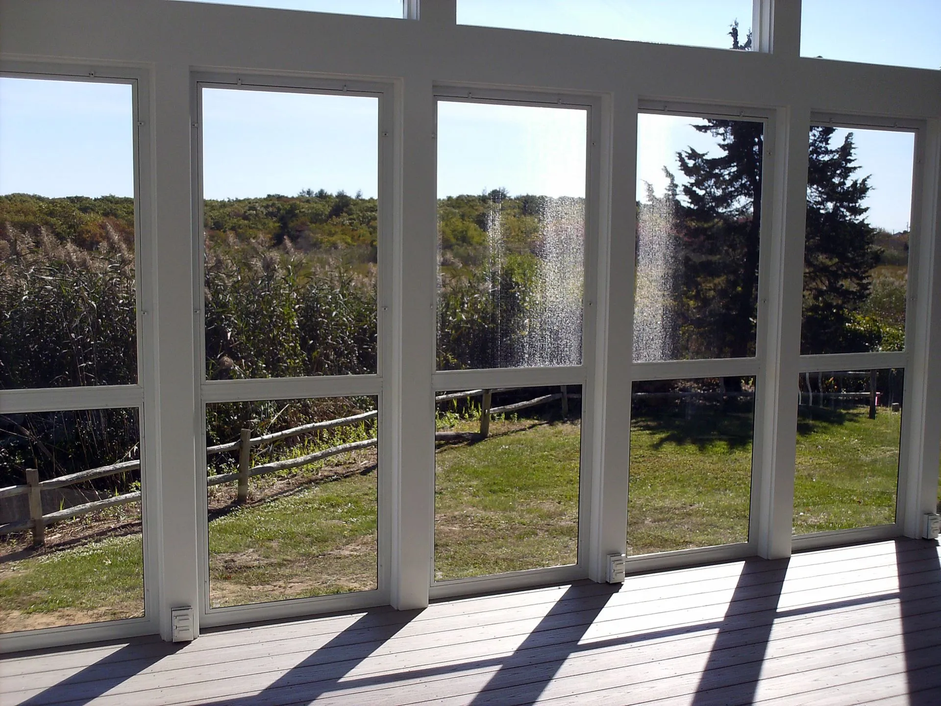 a screened in porch with a fountain in the background