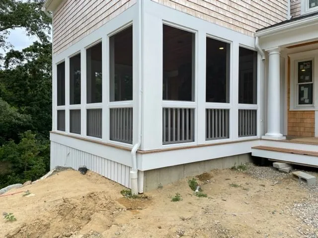 a screened in porch on the side of a house