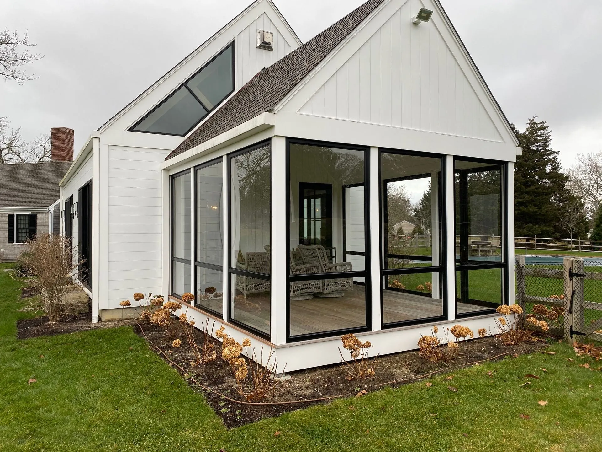 a white house with a screened in porch in the backyard