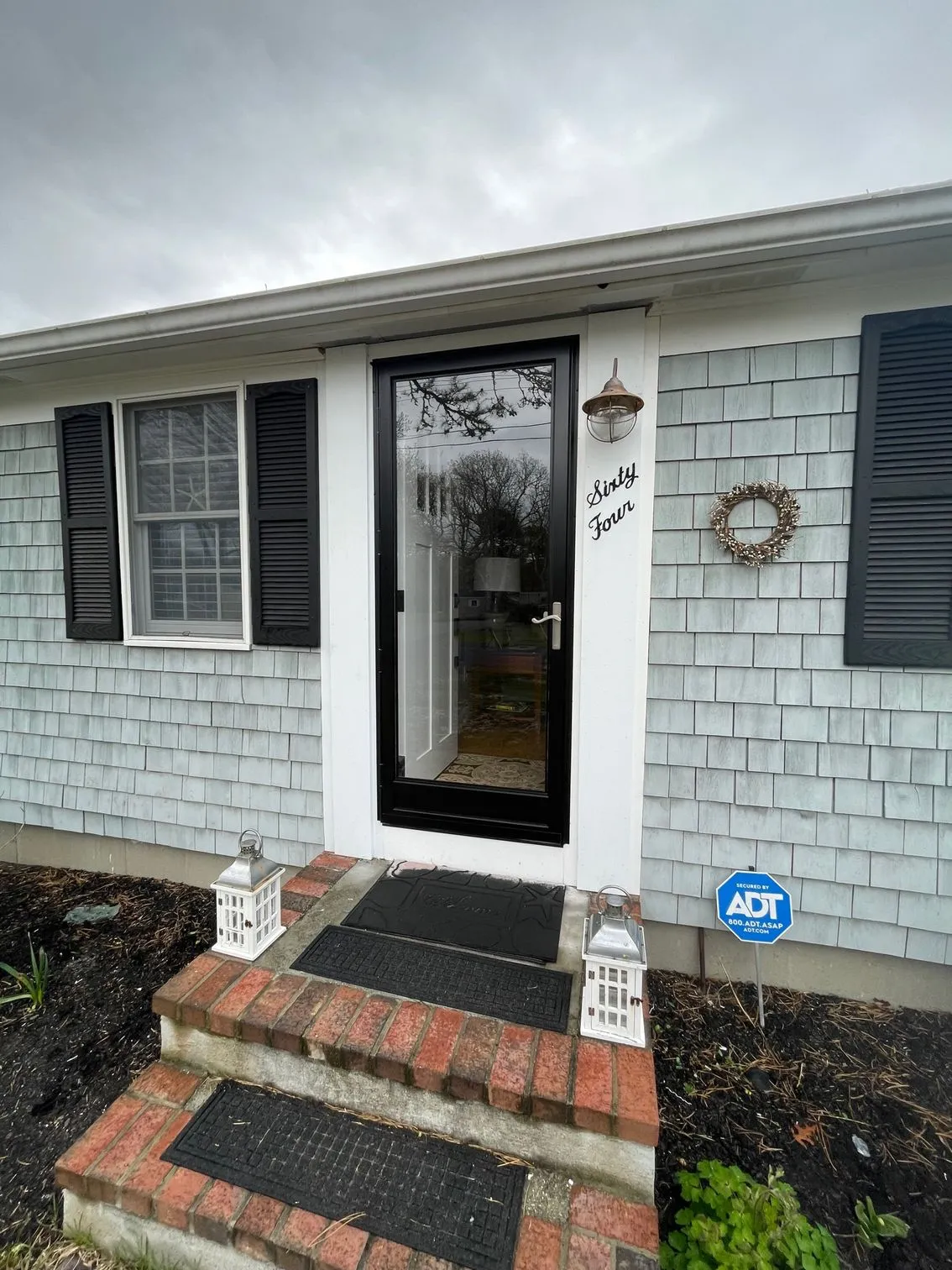 a white house with black shutters and a black door