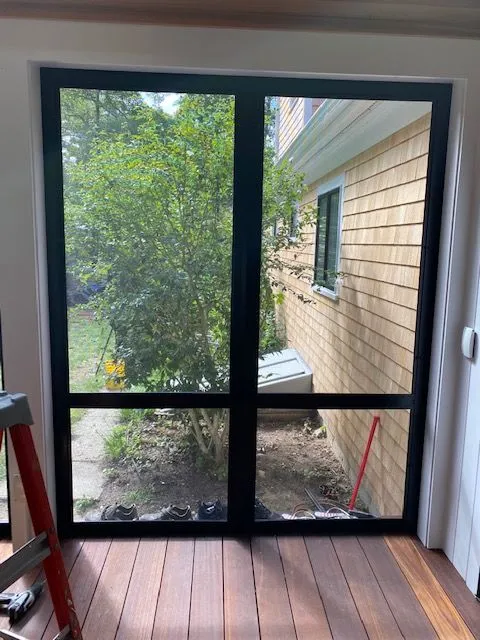 a ladder is sitting on a wooden floor next to a sliding glass door