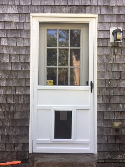 a white door with a cat door on the side of it