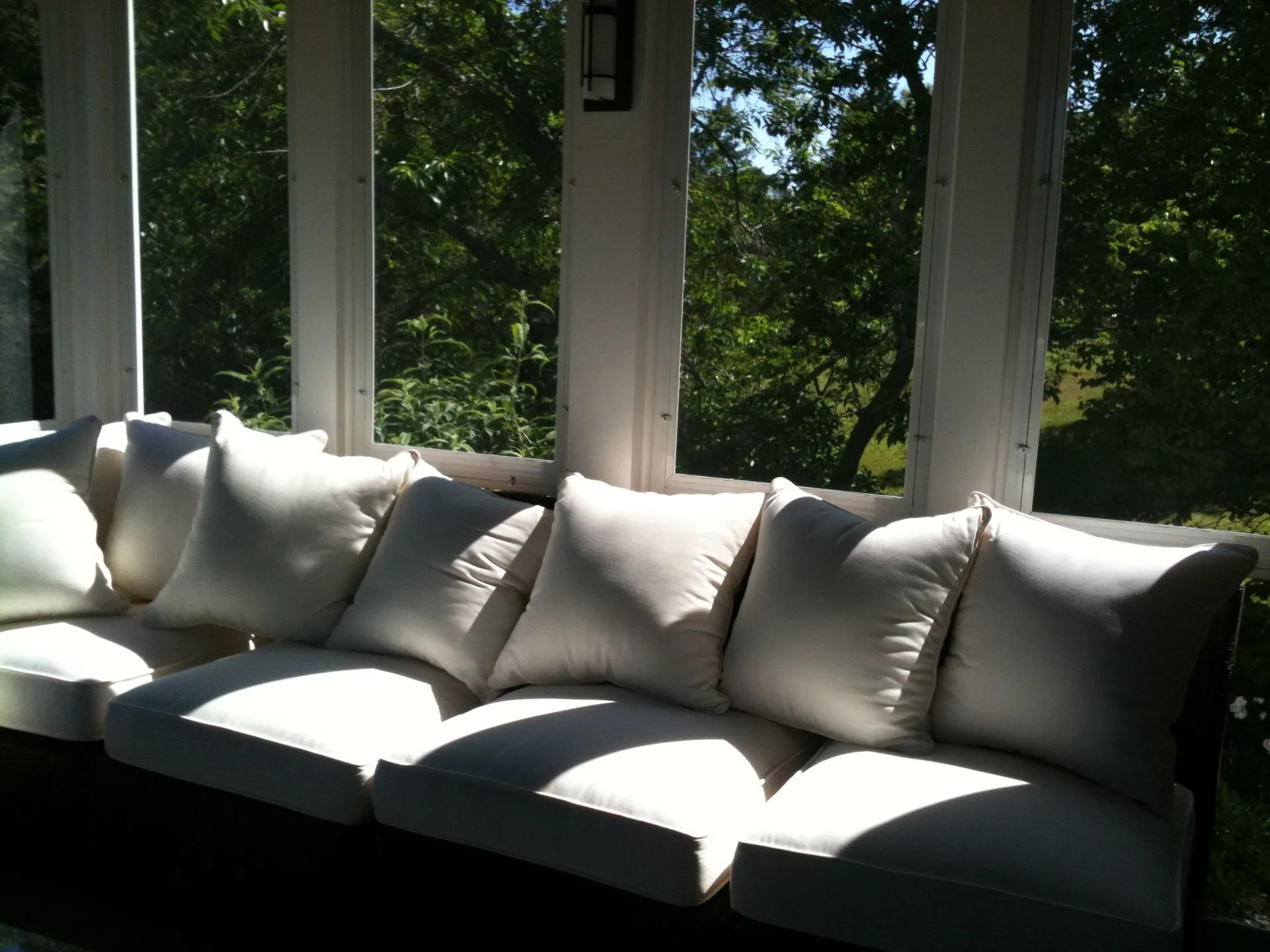 a couch with white pillows sits in front of a window