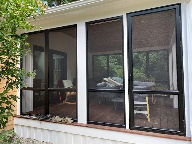 a screened in porch with a couch and chairs in it