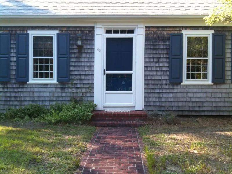 a house with blue shutters and a screen door