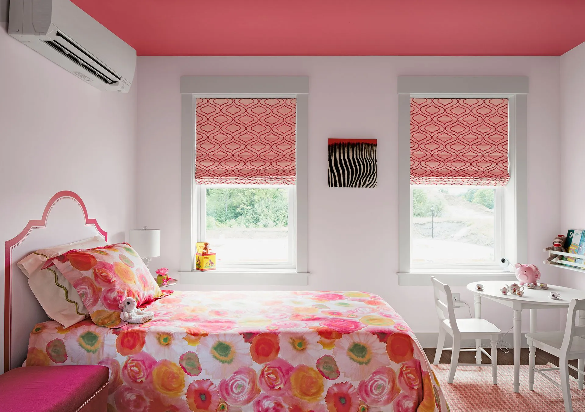 a bedroom with a pink ceiling , a bed , a table and chairs
