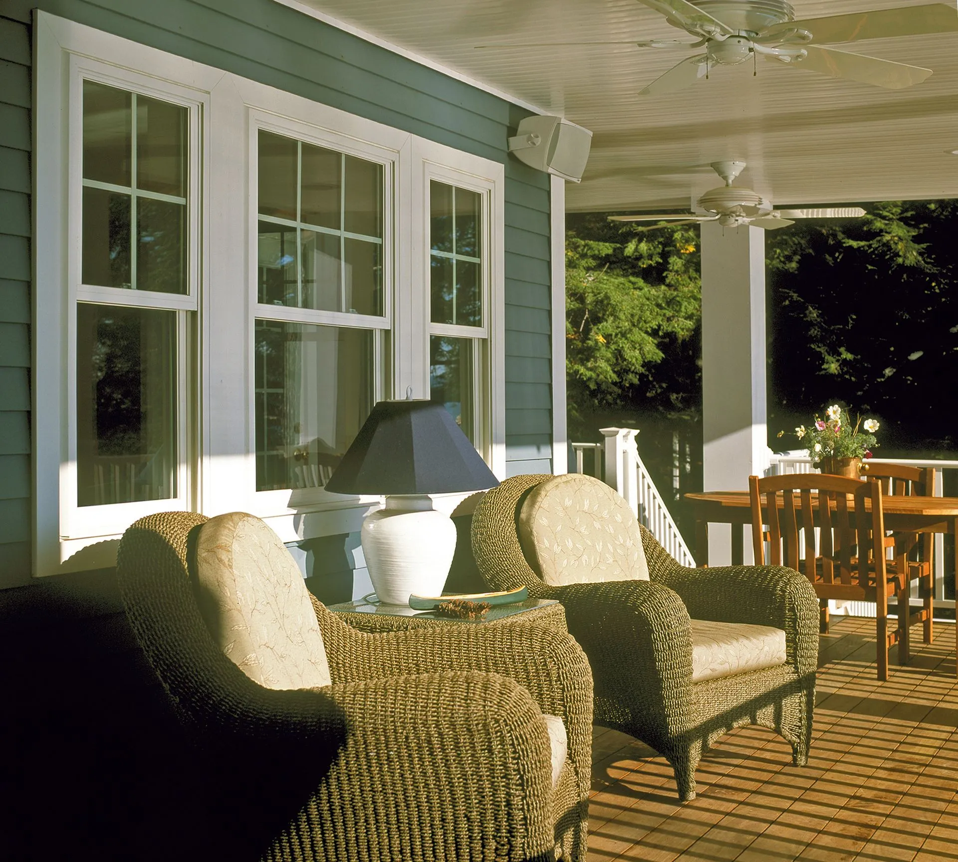 a porch with wicker furniture and a ceiling fan
