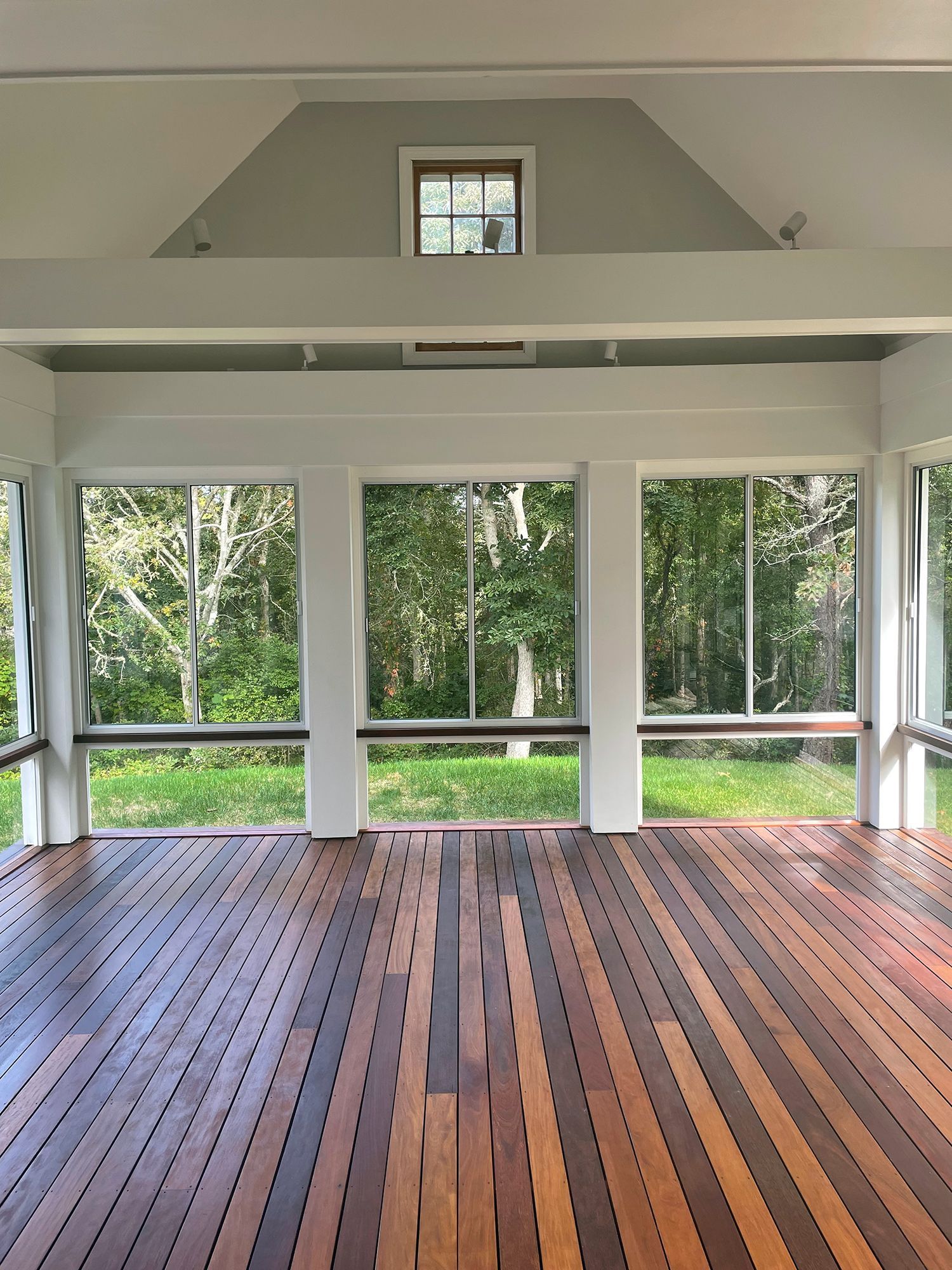 a room with a wooden floor and lots of windows