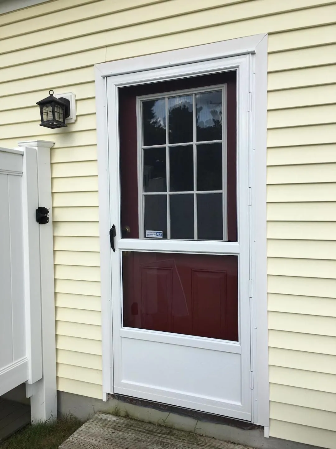 a red door with a white frame is on the side of a house