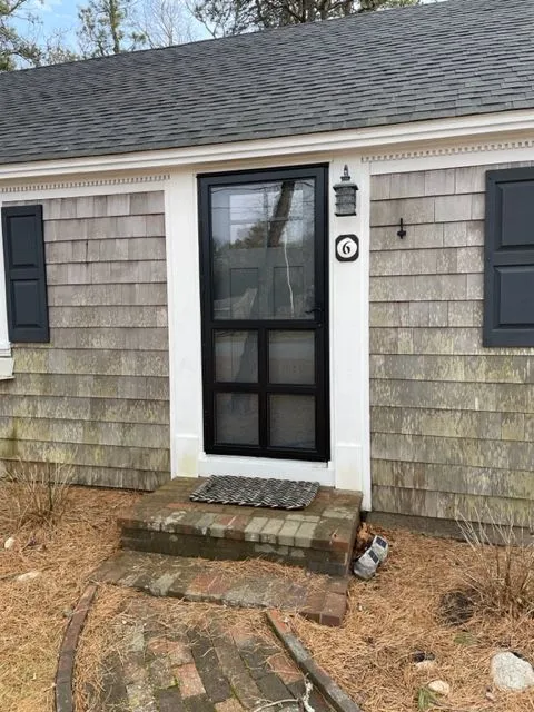 a small house with a black door and black shutters